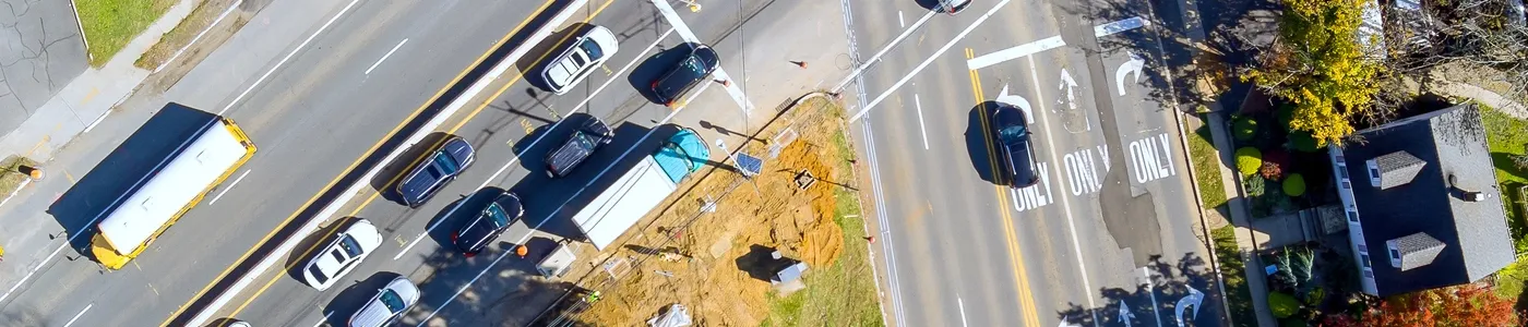 Aerial view of a city street with cars parked on the side of it